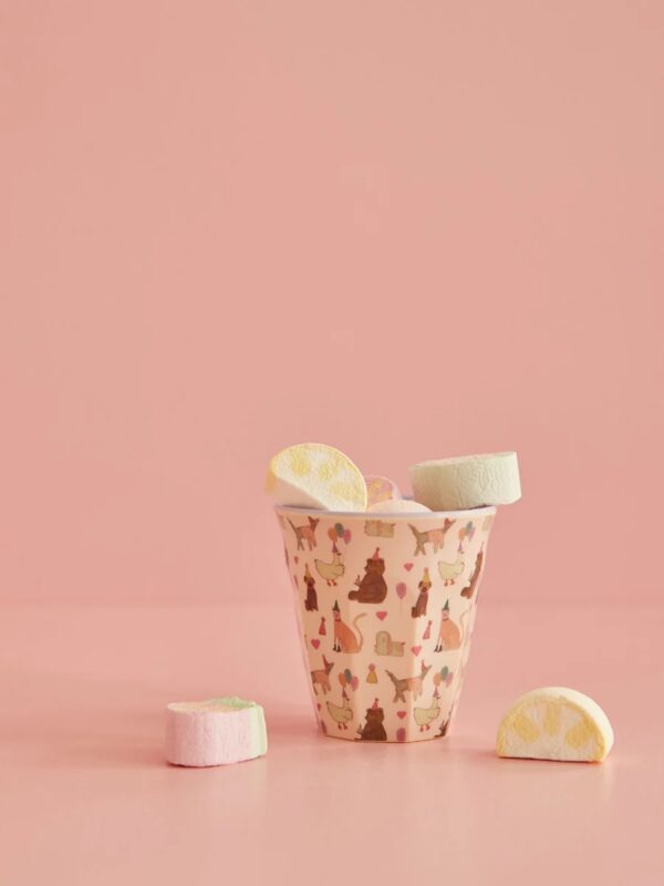 Rice Melamin Kinderbecher Größe Medium in Rosa mit Party Animals Print mit Marshmallows vor Apricot-Farbigem Hintergrund fotografiert