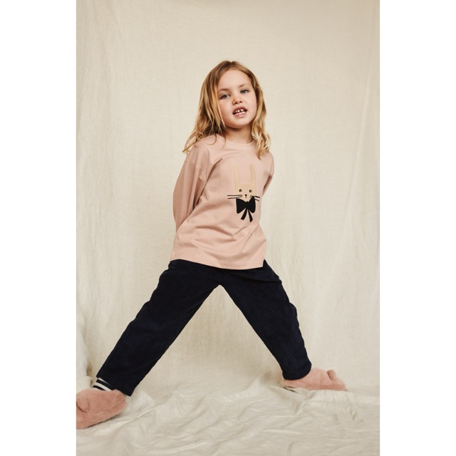 Mädchen trägt das Langarmshirt in Altrosa mit Hasenkopf und dunkelblauer Schleife