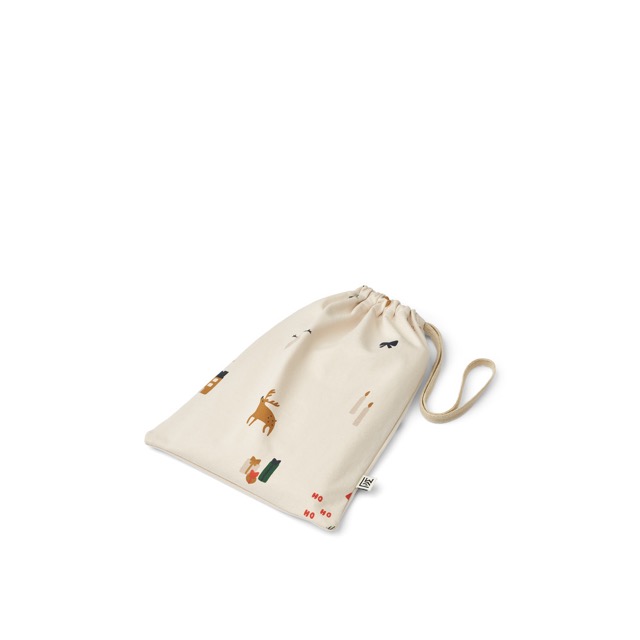 Weihnachtspyjama Jumpsuit von Liewood in Beige mit aufgderuckten weihnachtlichen Motiven in Stoffbeutel verpackt