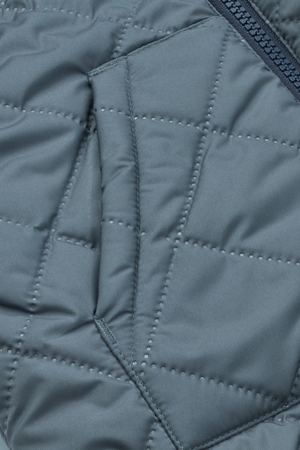 Wendejacke von Liewood in den Farben Blau, Beige, Weiß. Eine Seite in Teddy und eine Seite in Stepp mit Kapuze (Detailansicht Stellung)