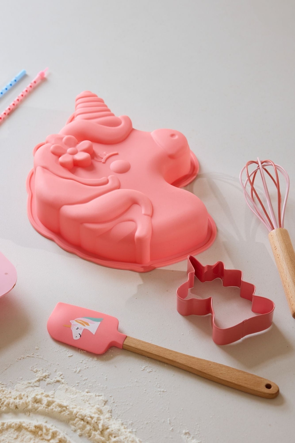 Einhorn Backset von Rice bestehend aus einer Einhorn Silikonbackvorm, einem Einhorn Keksausstecher, einem rosa Schneebesen und einem rosa Silikonschaber mit Einhornaufdruck