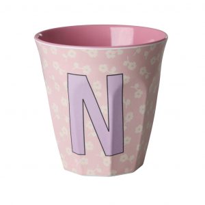 Buchstabenbecher von Rice mit Buchstabe N in Flieder auf rosa Hintergrund mit beigen Blumen