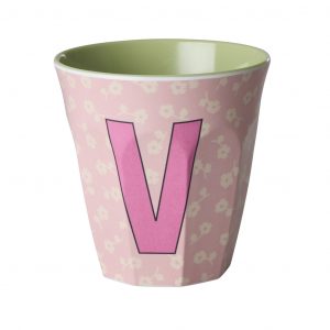 Rice Buchstabenbecher mit Buchstabe V in Pink auf rosa Hintergrund mit beigen Blumen