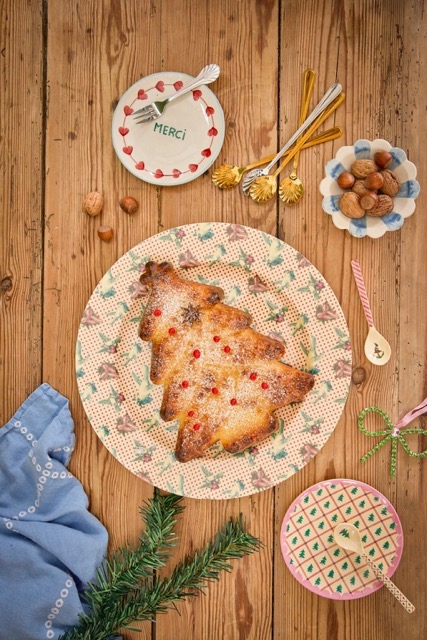 fertig gebackener Kuchen in der Weihnachtsbaum-Form gebacken auf einem Weihnachtsteller von Rice auf einem Holztisch stehend