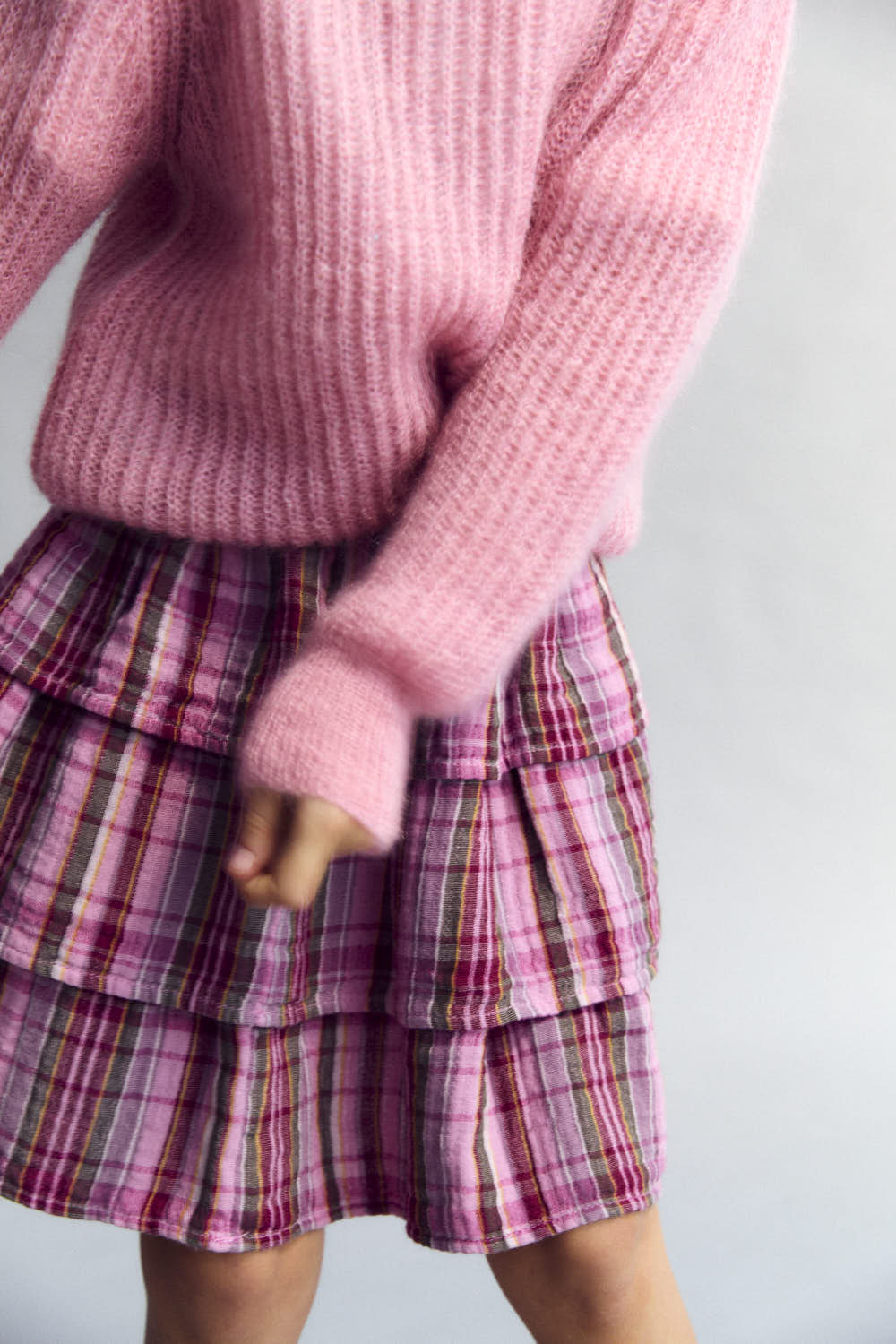 Rosa karierter Baumwollrock mit beige Gummiband in das der Text "The New Society" eingewebt ist.