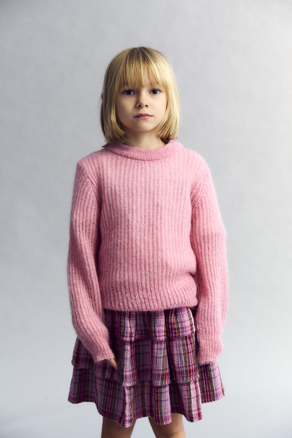 Rosa karierter Baumwollrock mit beige Gummiband in das der Text "The New Society" eingewebt ist.