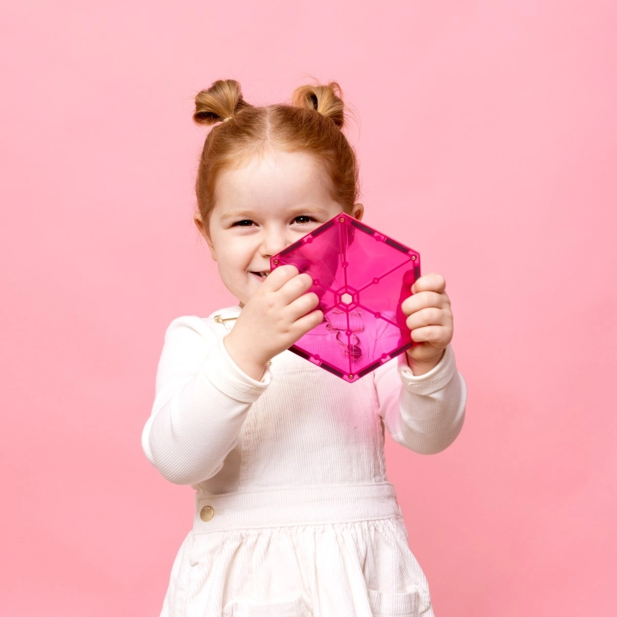 Mädchen dass einen pinken Stein aus der Connetix Charity Box hochhält