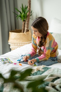 Kind Spielt Smart Games Hänsel & Gretel Grünes Spielbrett mit Spielfiguren Hänsel, Hexenhaus, Lollis & Bonbons